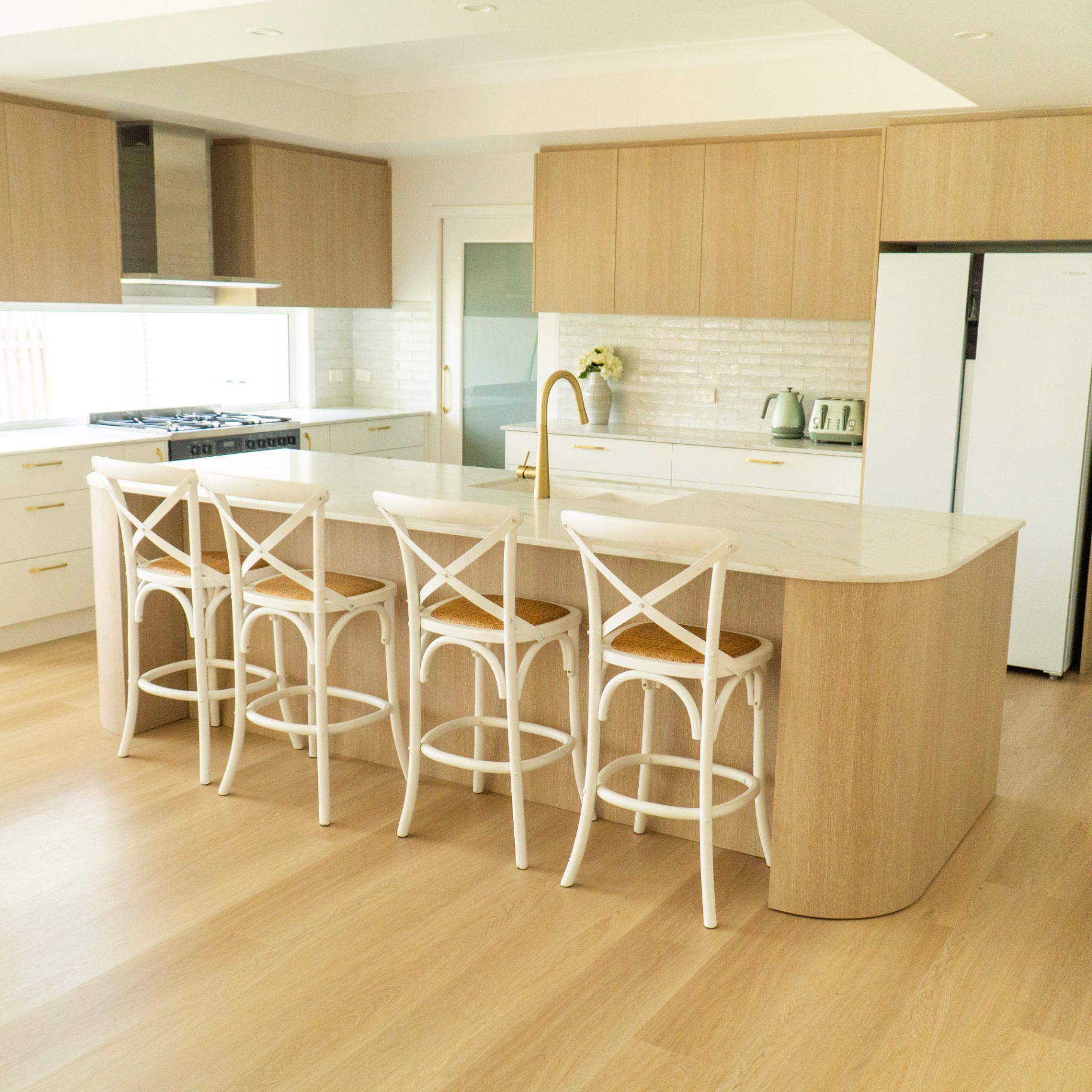 Coastal oak kitchen with sweeping Naica island